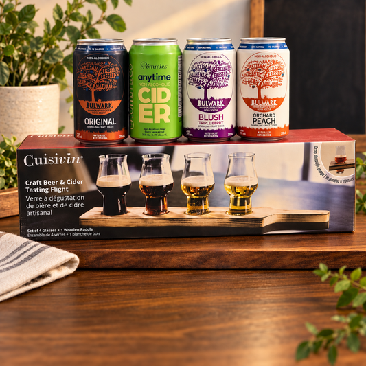 A flight board with 4 non alcoholic ciders in a kitchen with wooden counter and plants 