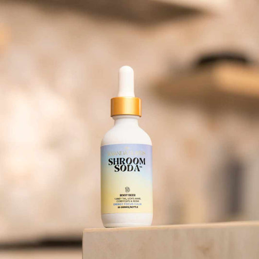 Root Beer Shroom Soda dropper bottle on a wooden surface with a blurred background